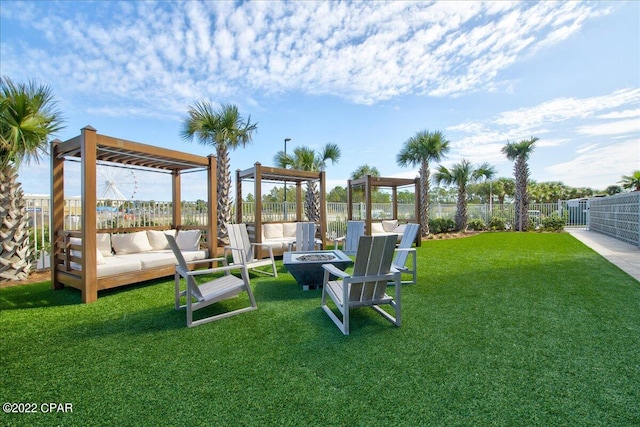 view of yard with an outdoor living space with a fire pit