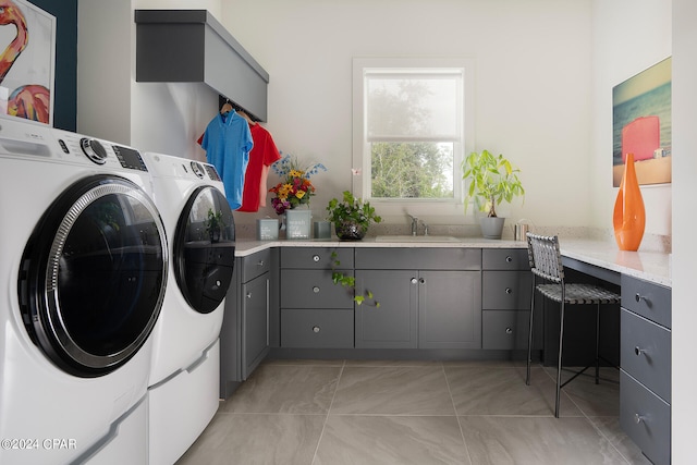 clothes washing area featuring cabinets, washer and dryer, light tile floors, and sink