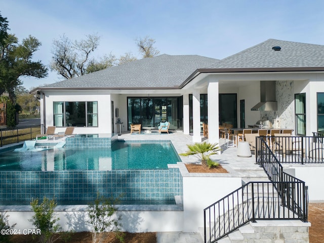 rear view of property featuring a pool with hot tub, a patio, and a bar