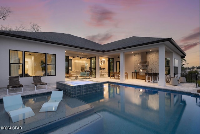 pool at dusk featuring ceiling fan, area for grilling, and a patio area