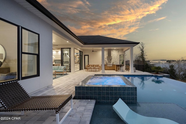 pool at dusk featuring a patio area and outdoor lounge area