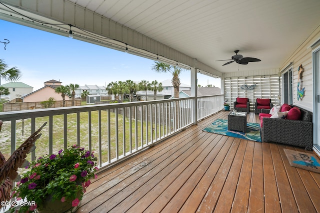 wooden terrace featuring a lawn, outdoor lounge area, and ceiling fan