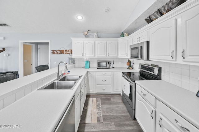 kitchen featuring white cabinets, dark hardwood / wood-style floors, backsplash, and stainless steel appliances