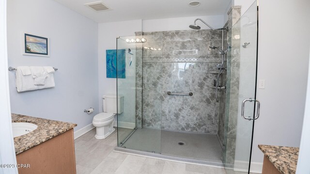 bathroom with toilet, tile flooring, walk in shower, and vanity