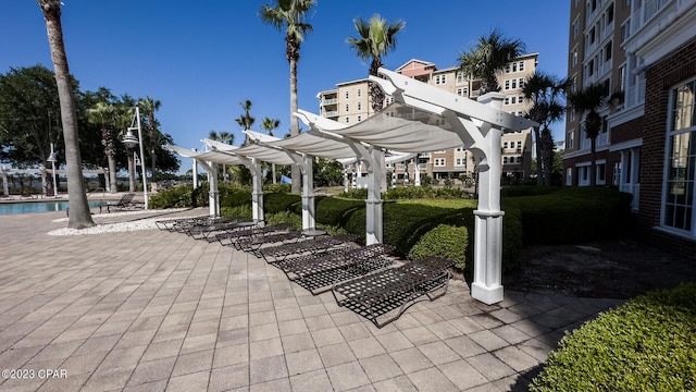 view of property's community featuring a swimming pool, a pergola, and a patio