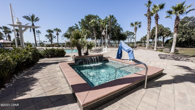 view of swimming pool with a hot tub and a patio area