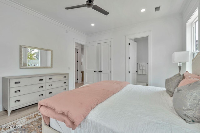 bedroom featuring a closet, light hardwood / wood-style flooring, ceiling fan, and connected bathroom