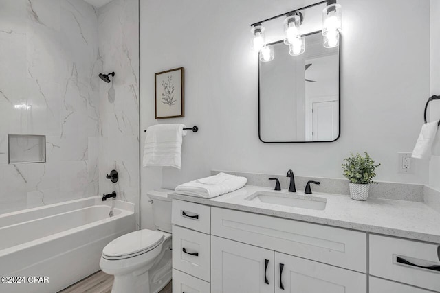 full bathroom featuring tiled shower / bath, toilet, vanity, and hardwood / wood-style floors