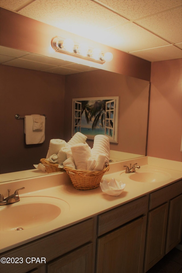 bathroom featuring dual vanity and a drop ceiling