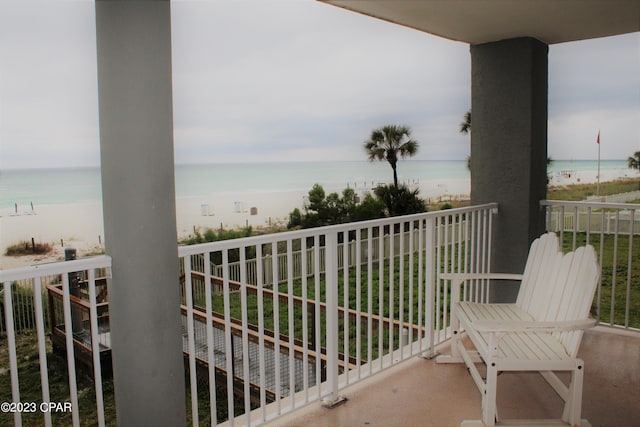 balcony featuring a beach view and a water view