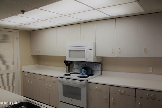 kitchen with white appliances, gray cabinetry, and a drop ceiling