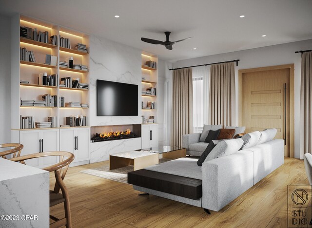 living room with ceiling fan, a fireplace, light hardwood / wood-style floors, and built in shelves