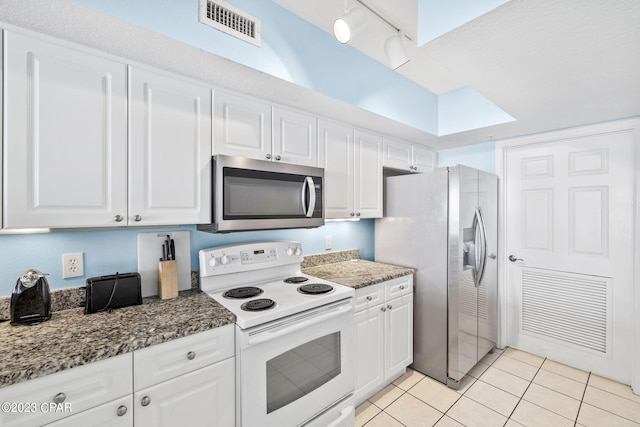 kitchen with light tile patterned floors, stainless steel appliances, visible vents, and white cabinets