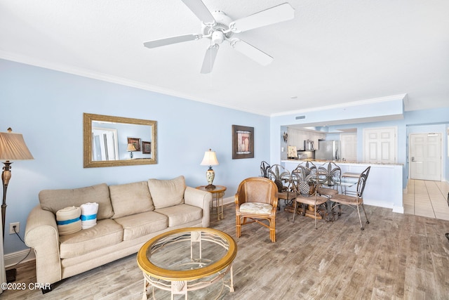 living area with a ceiling fan, baseboards, light wood-style floors, and crown molding