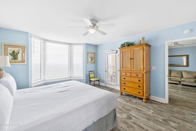 bedroom with baseboards, multiple windows, and wood finished floors