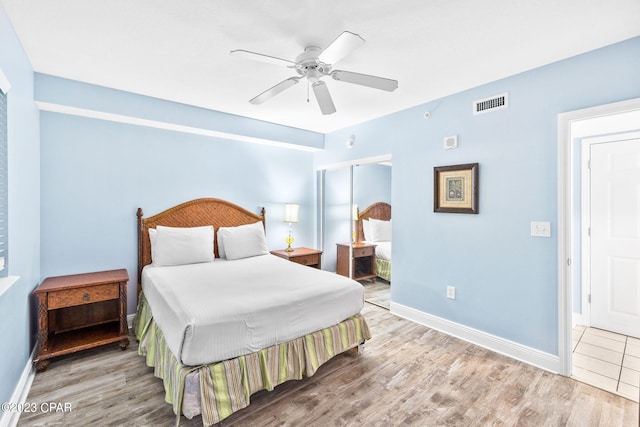 bedroom with wood finished floors, visible vents, and baseboards