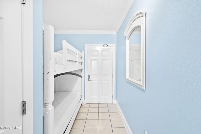 laundry room featuring crown molding, light tile patterned flooring, baseboards, and a textured ceiling