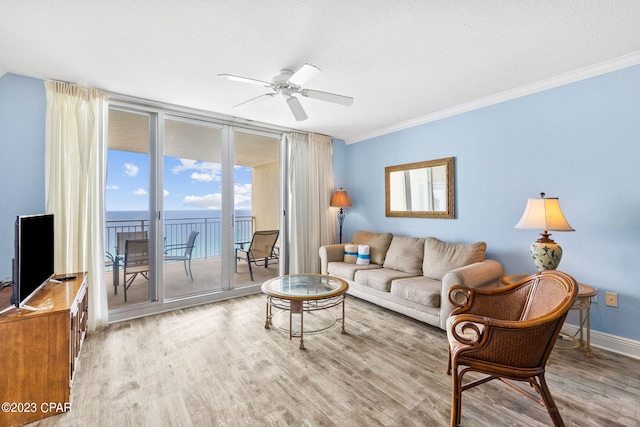 living room featuring crown molding, wood finished floors, baseboards, and ceiling fan