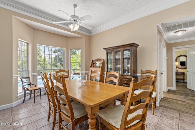 dining area with visible vents, a textured ceiling, baseboards, and ornamental molding