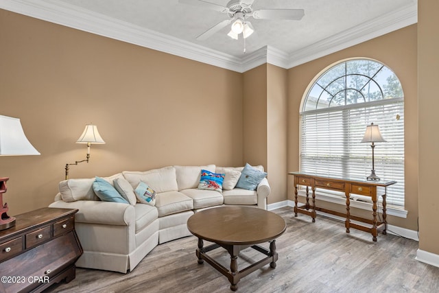 living room with ceiling fan, baseboards, wood finished floors, and ornamental molding