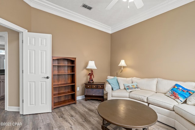 living room with ceiling fan, wood finished floors, baseboards, and ornamental molding