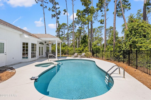 view of pool featuring a pool with connected hot tub, ceiling fan, french doors, a fenced backyard, and a patio area