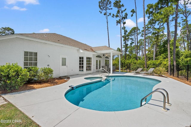 view of pool featuring a fenced in pool, fence, french doors, a patio area, and an in ground hot tub