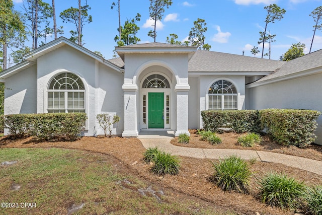 view of front of property with stucco siding and roof with shingles