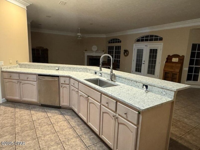 kitchen with light tile patterned floors, a peninsula, a sink, stainless steel dishwasher, and crown molding