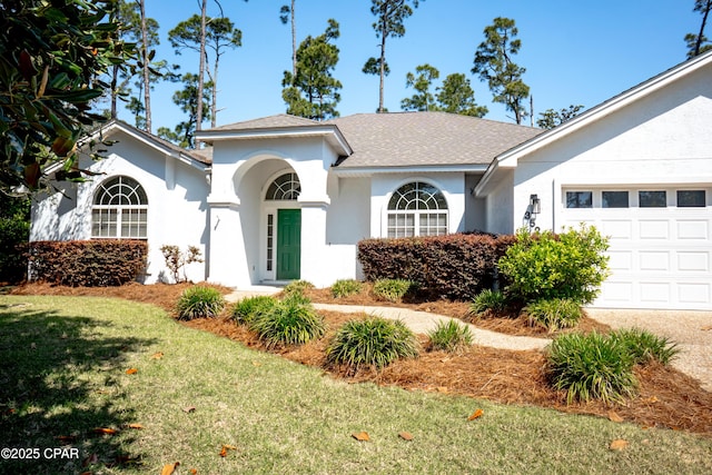 3522 Fox Run Blvd, Panama City, FL 32408 - view of front facade featuring an attached garage, a shingled roof, a front lawn, and stucco siding