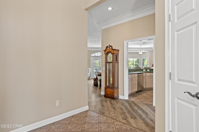 corridor with recessed lighting, baseboards, dark tile patterned flooring, and crown molding