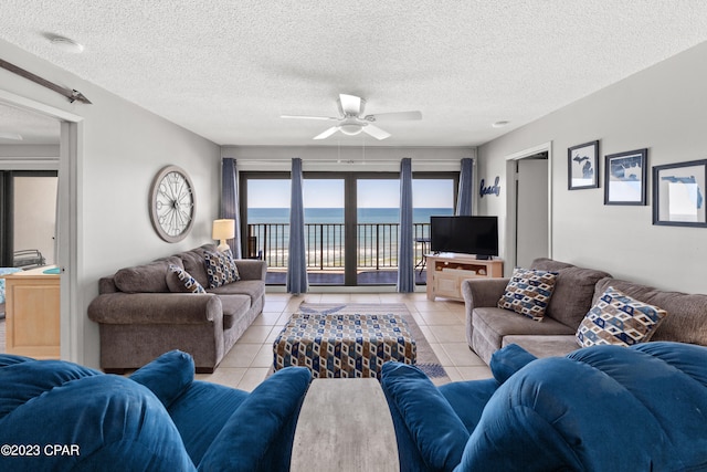 tiled living room featuring a textured ceiling and ceiling fan