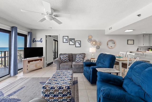 tiled living room featuring ceiling fan and a textured ceiling