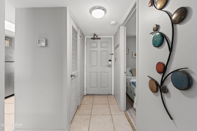 interior space with a textured ceiling and light tile patterned floors