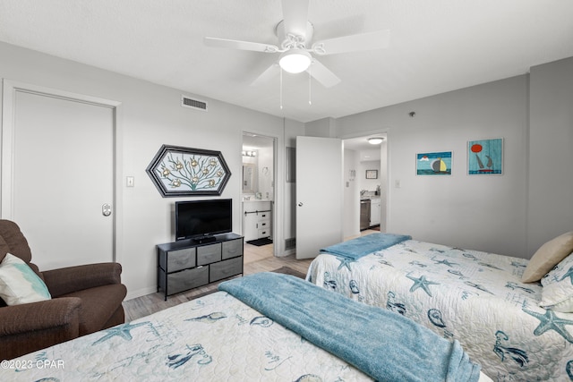 bedroom featuring light hardwood / wood-style floors, ceiling fan, and ensuite bathroom