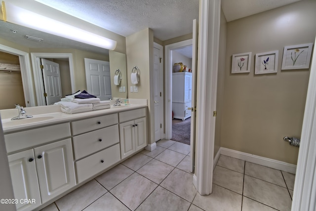 bathroom featuring tile patterned flooring, a textured ceiling, and vanity