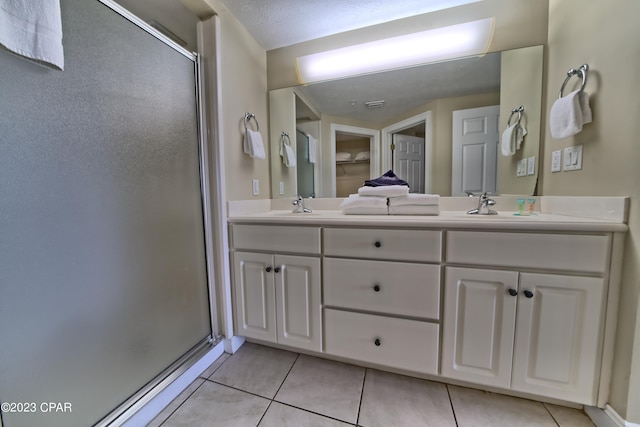 bathroom featuring vanity, tile patterned floors, and walk in shower