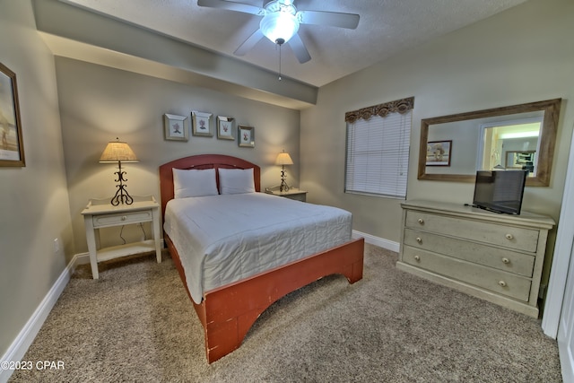 carpeted bedroom featuring ceiling fan and a textured ceiling