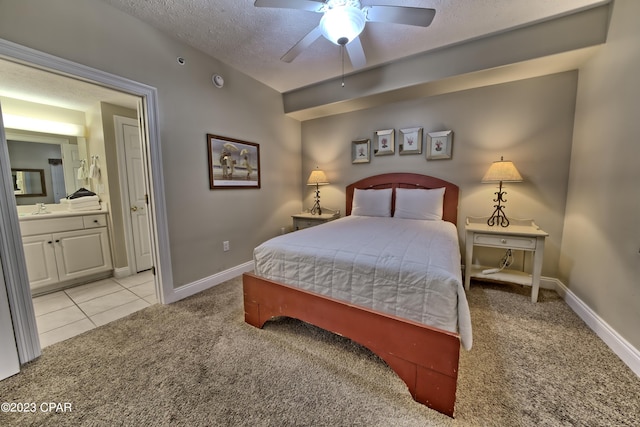 carpeted bedroom featuring a textured ceiling, ensuite bathroom, ceiling fan, and sink