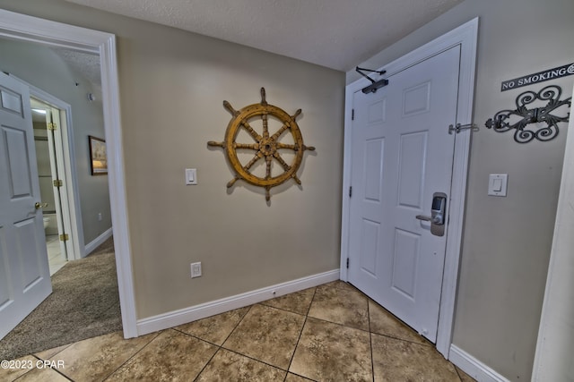 foyer featuring tile patterned floors and a textured ceiling