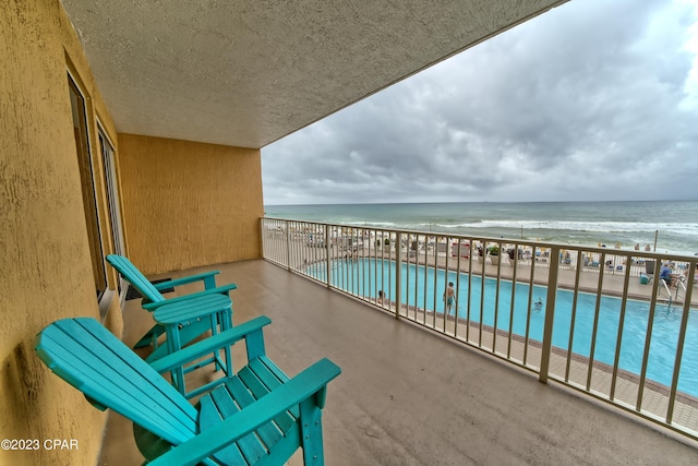 balcony with a water view and a beach view