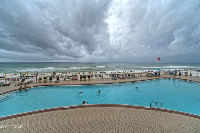 view of swimming pool with a view of the beach and a water view