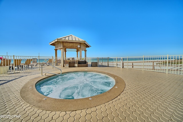 view of pool with a community hot tub, a water view, and a patio