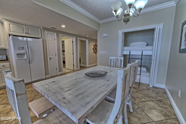 dining room with light tile patterned floors, ornamental molding, a textured ceiling, and a notable chandelier