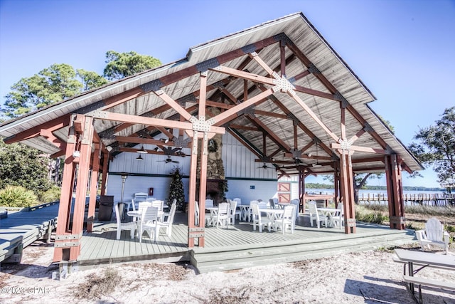 view of home's community featuring outdoor dining area, a gazebo, and a deck with water view