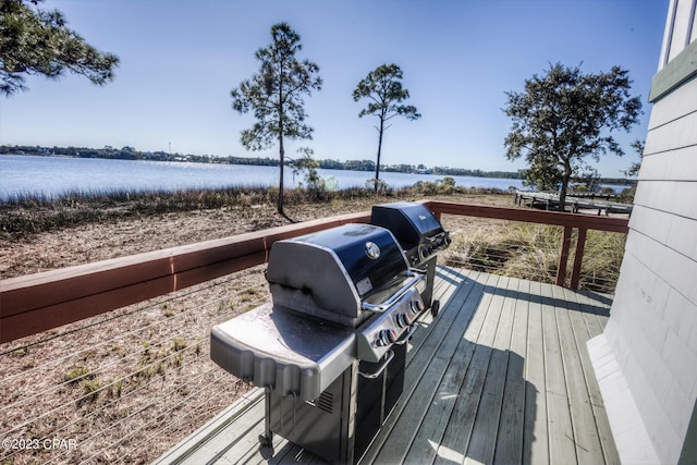 wooden terrace with grilling area and a water view