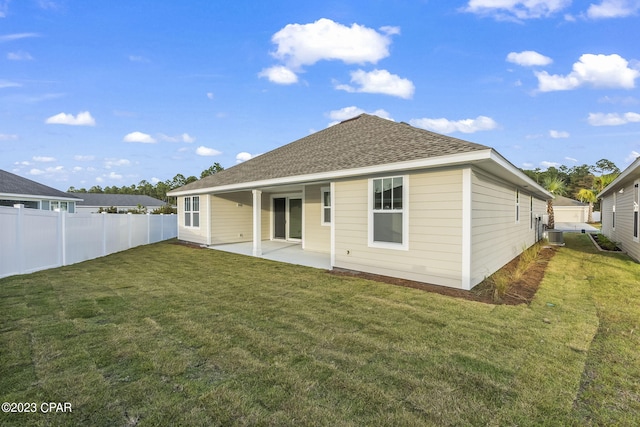 rear view of property with a lawn, a patio area, and cooling unit