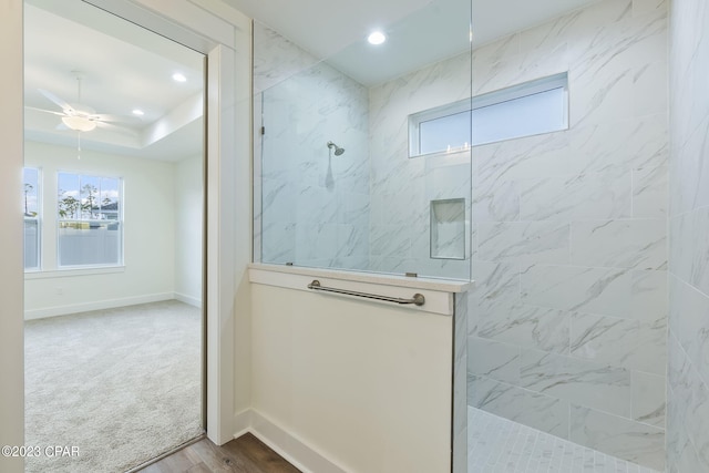 bathroom featuring a tile shower, hardwood / wood-style flooring, and ceiling fan