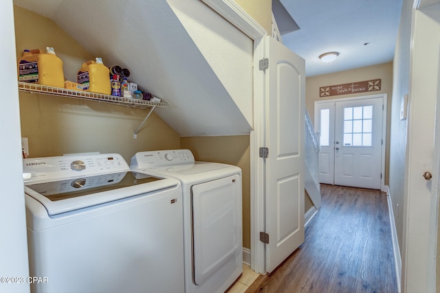 clothes washing area with washer and clothes dryer and light hardwood / wood-style flooring