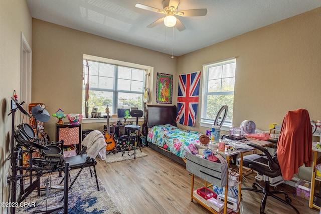 bedroom with light hardwood / wood-style floors and ceiling fan